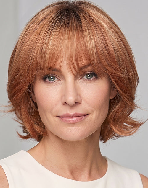 Front view shot of the Alma strawberry blonde highlighted short wavy bob wig with bangs.