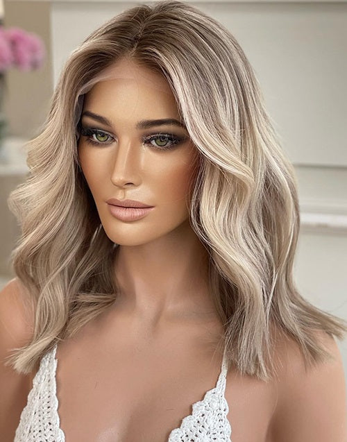 Side view of a woman wearing an ash blonde wavy short bob human hair wig.