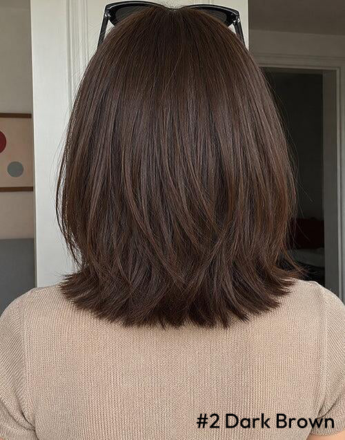 Back view of a person with shoulder-length dark brown layered hair.