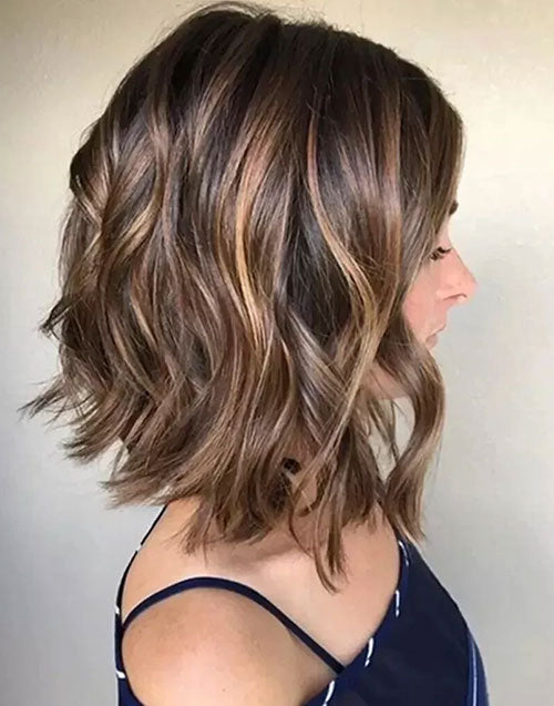 Side profile of a woman wearing a short wavy bob human hair wig with subtle caramel brown balayage highlights