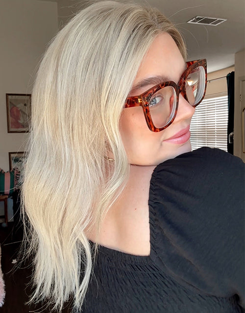 A detailed side profile view of a model wearing a cool platinum ash blonde wavy human hair glueless bob wig.