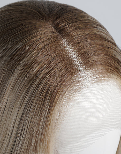 Close-up of a brown and blonde ombré wig on a mannequin head, showing the hair texture, parting, and lace front attachment.