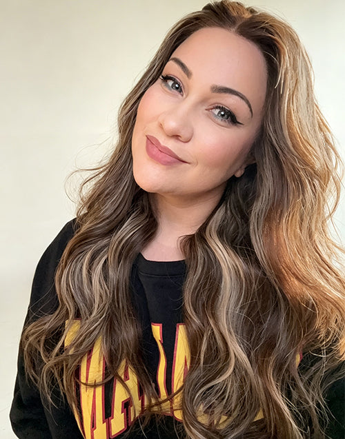 Woman smiling with long wavy lace wig featuring sun-kissed honey blonde balayage, seamless hairline, and soft cascading waves.