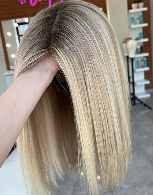 A detailed closeup view of an ombre ash blonde straight human hair glueless bob wig, showing the natural hairline.