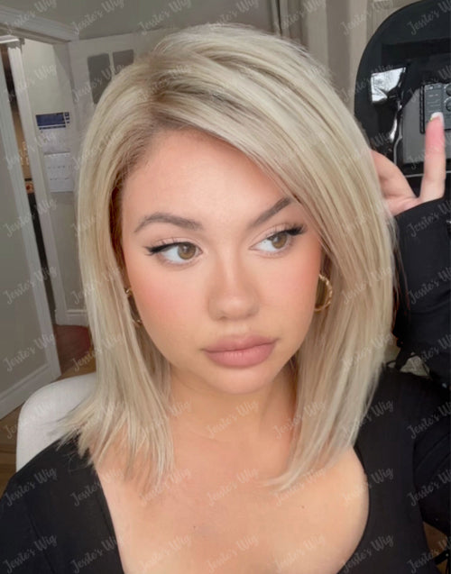 Front view selfie of a model wearing an ombre ash blonde straight human hair bob wig with a natural side part and realistic hairline.