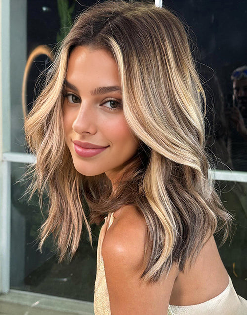 Front view of a shoulder-length wavy bob human hair wig featuring bright blonde face-framing money piece highlights and a natural lace hairline.
